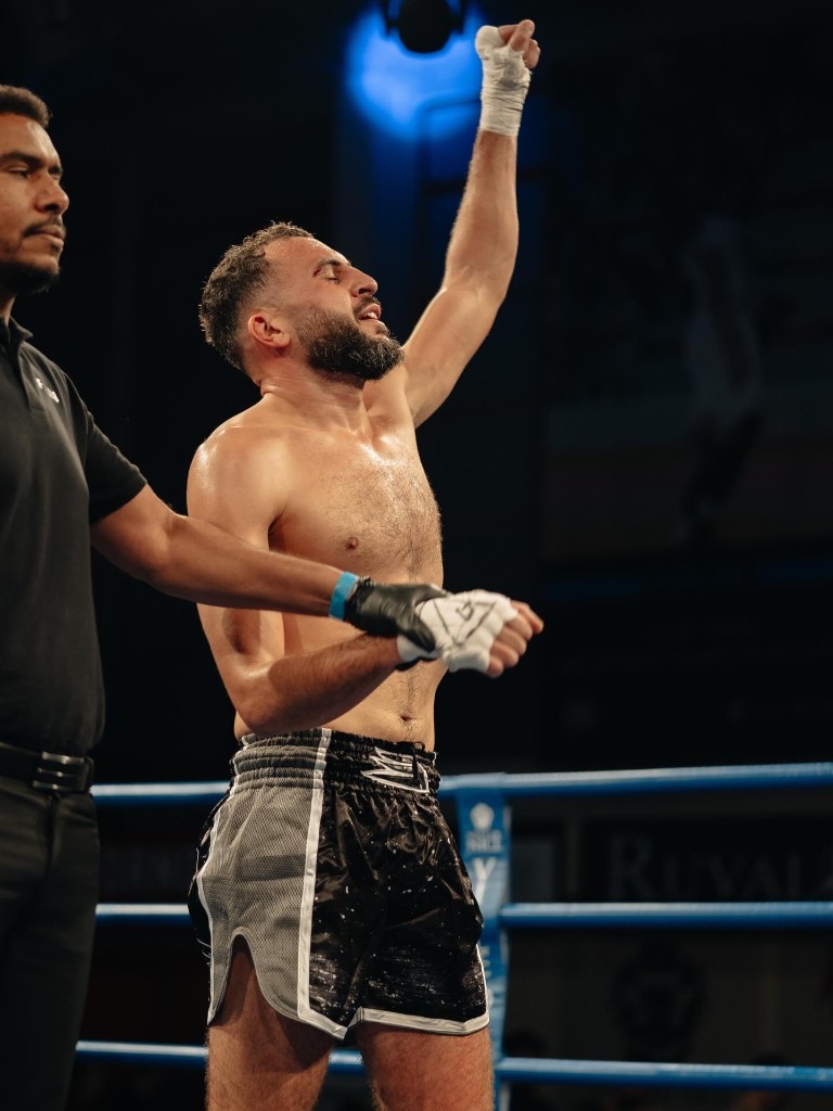 Karim vainqueur, bras levé par l'arbitre